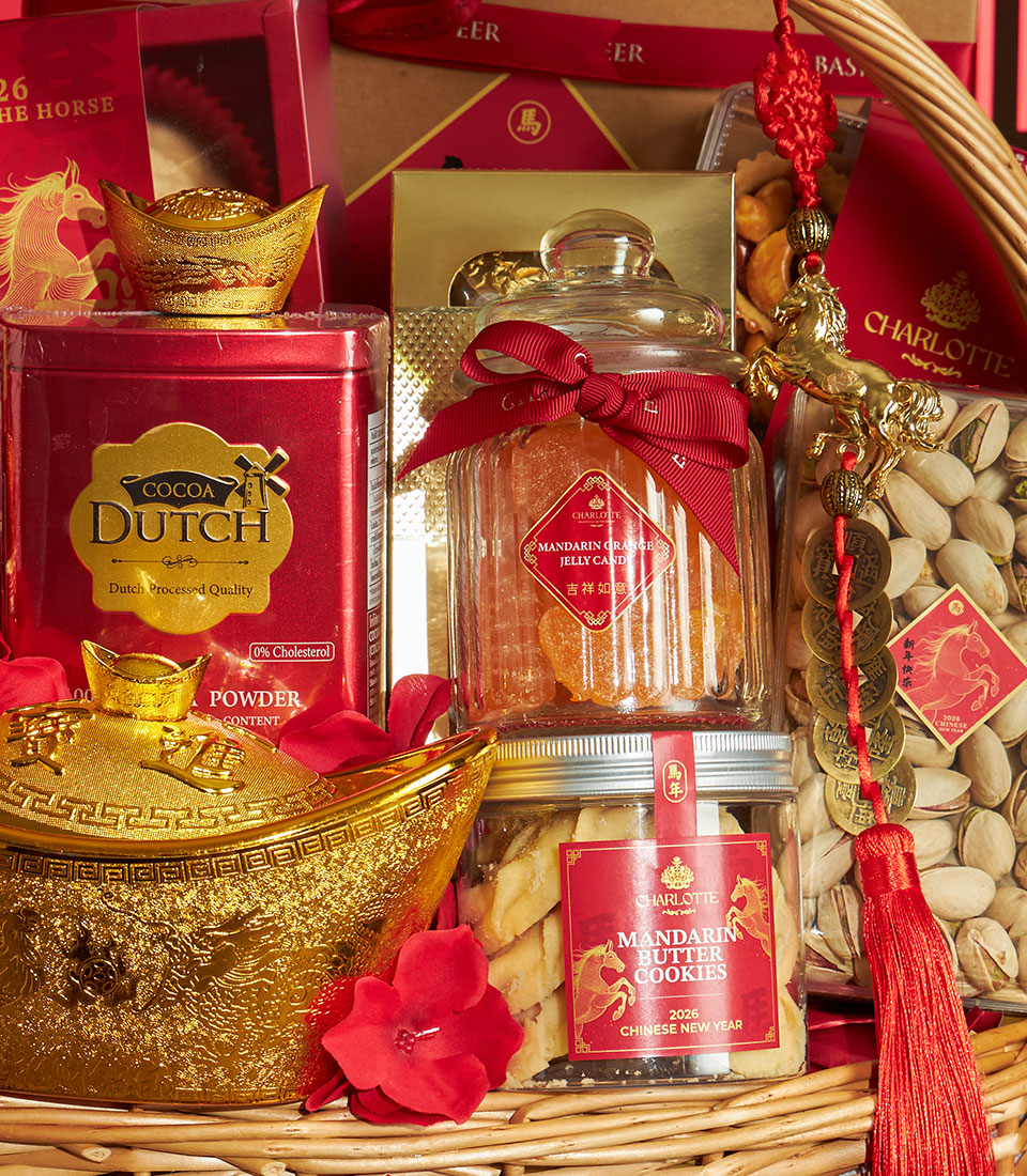 Red and gold Chinese New Year gift basket with cocoa powder, mandarin jelly candy, butter cookies, and prosperity symbols