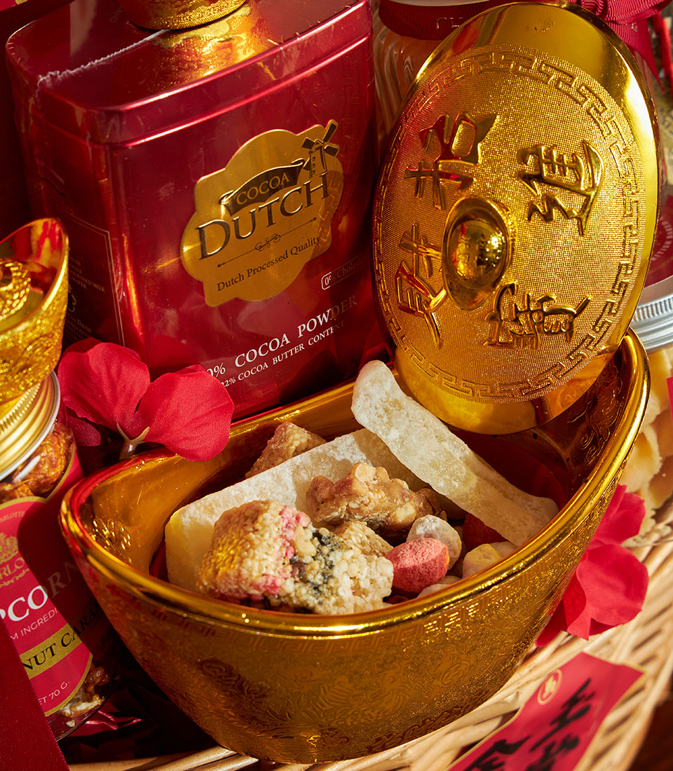 Prosperity Gourmet Chinese New Year gift basket with cocoa powder, sycee-shaped snack container, and festive red accents in