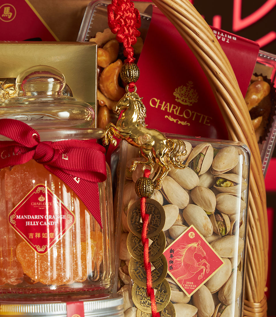 Red woven gift basket with mandarin jelly, pistachios, golden horse charm, and Chinese New Year treats