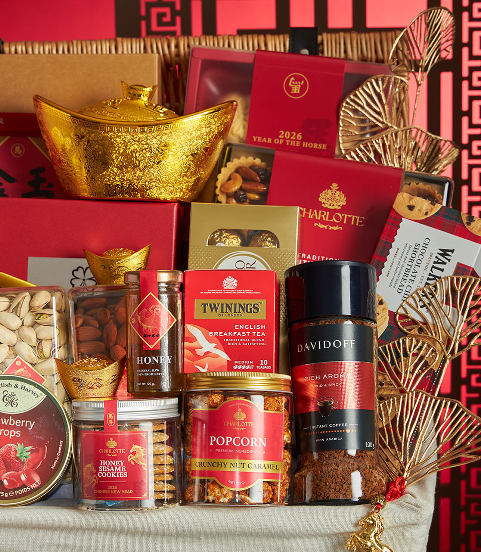 Luxury Chinese New Year gift basket with golden ingots, gourmet tea, honey, coffee and artisan treats on red festive