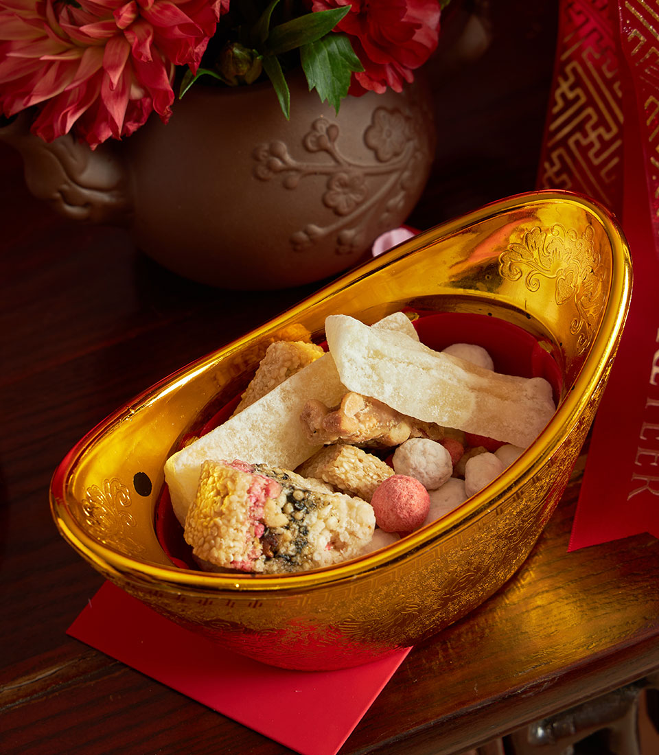 Golden yuanbao gift basket with festive Chinese New Year treats and non-alcoholic wine, red envelope styling