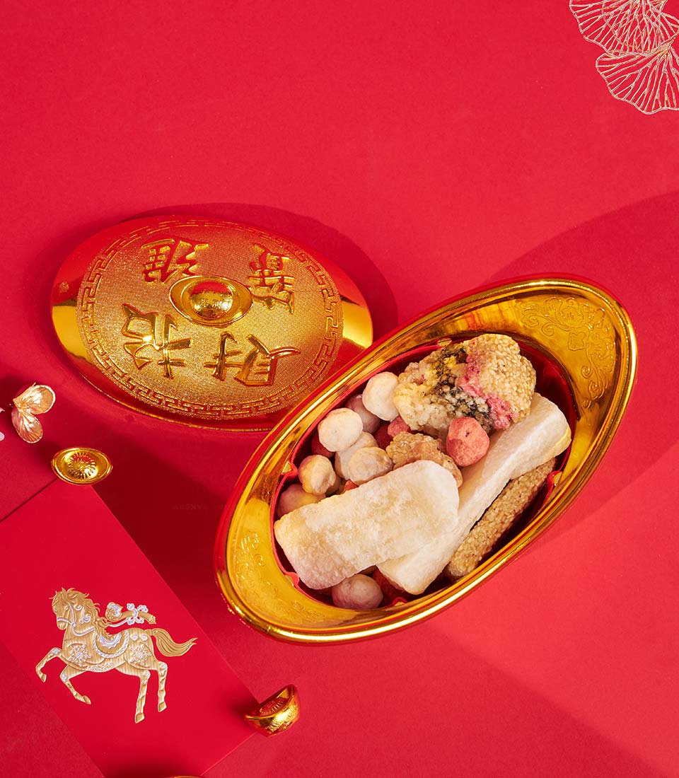 Golden festive container with Chinese New Year sweets, candies, and traditional snacks for prosperity celebrations