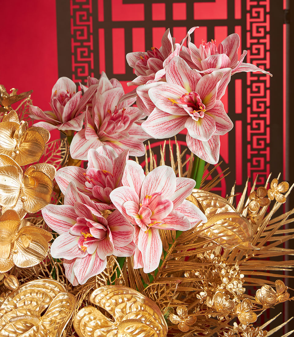 Basketeer premium hamper delivery Thailand: Golden floral arrangement with pink amaryllis and gilded accents. Perfect corporate gift Bangkok for Chinese New Year.