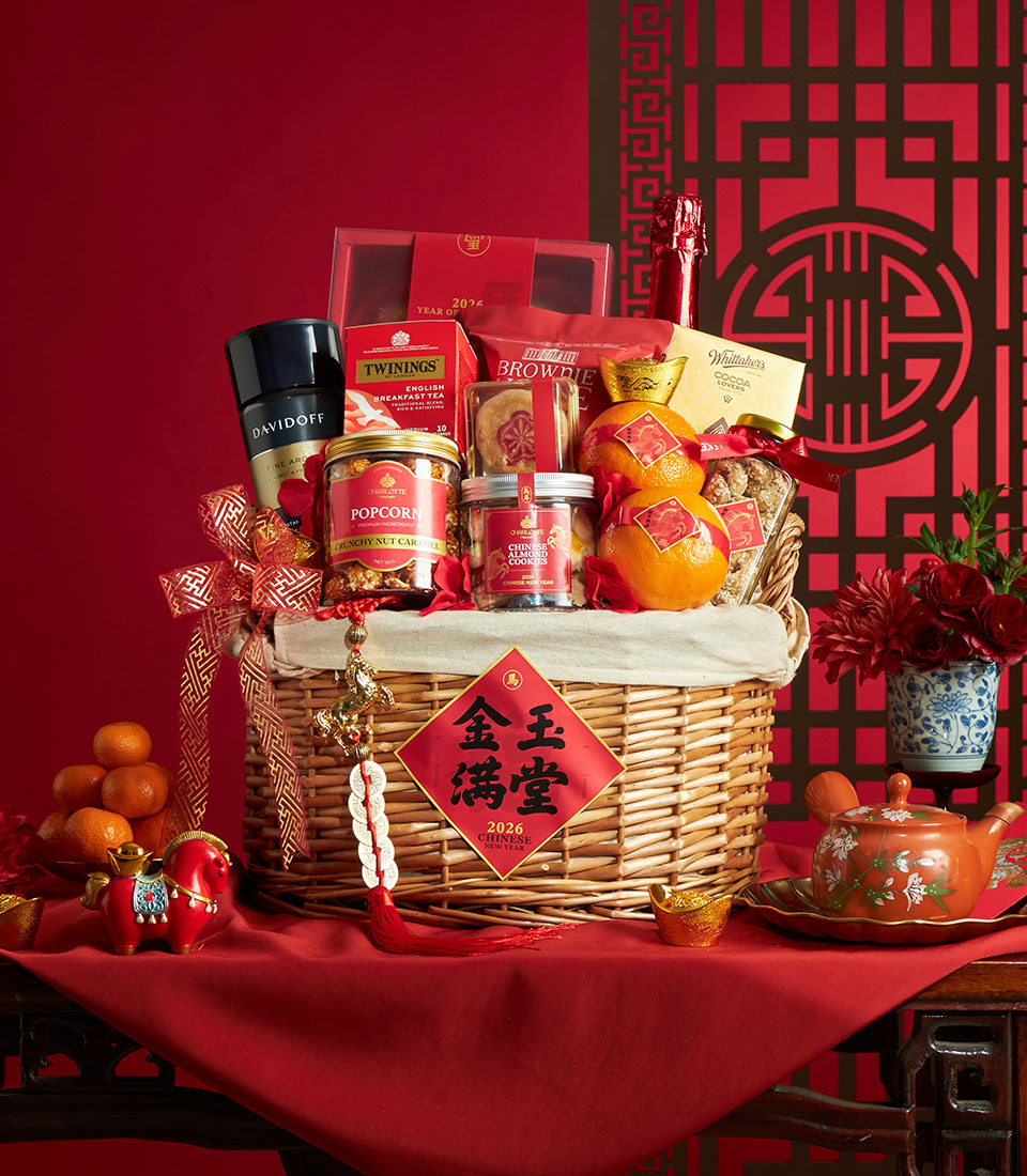 Festive red wicker gift basket with mandarin oranges, gourmet treats, and traditional Chinese New Year lucky charms