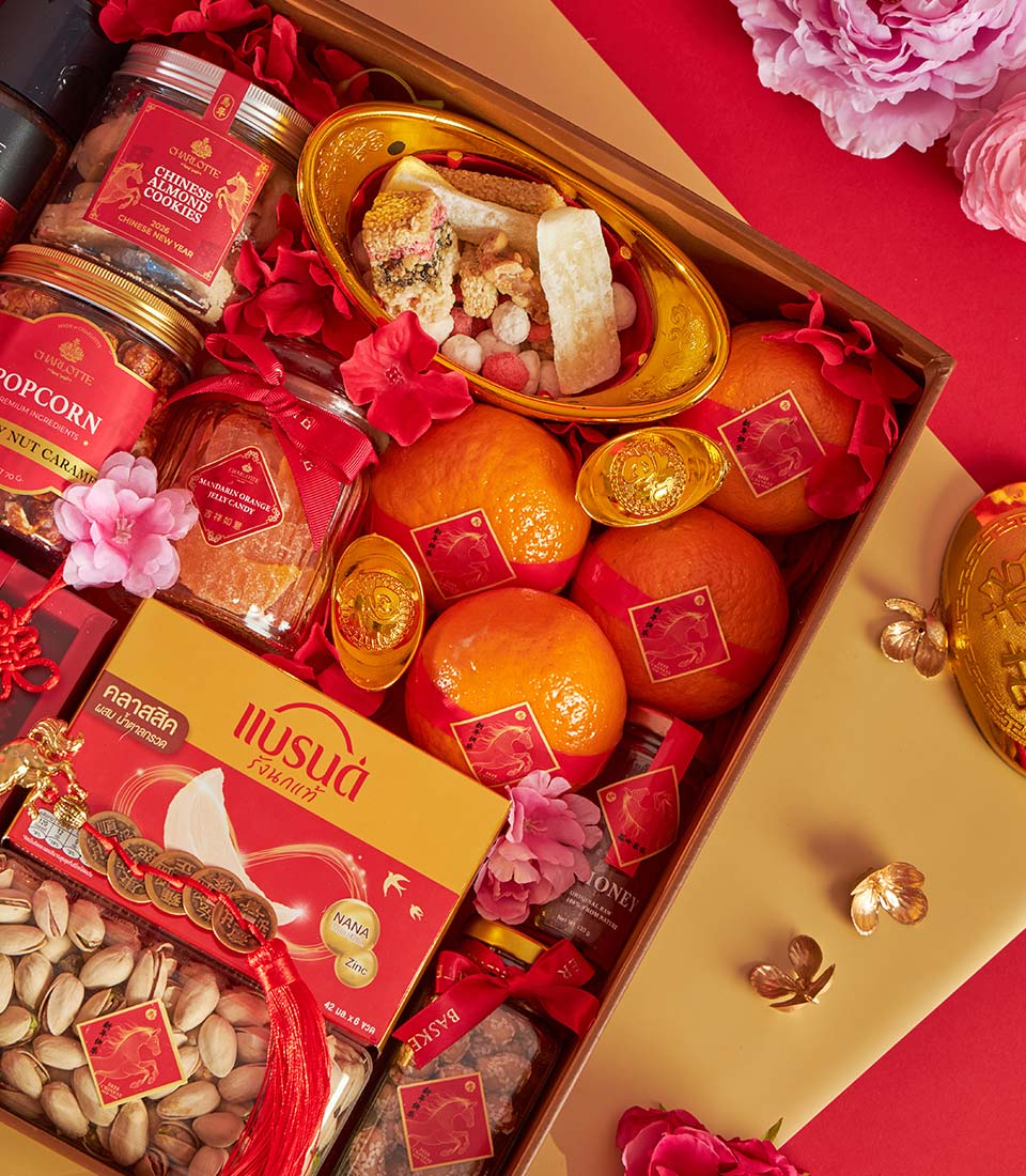 Premium Chinese New Year gift box with mandarin oranges, almond cookies, and traditional candies in red and gold