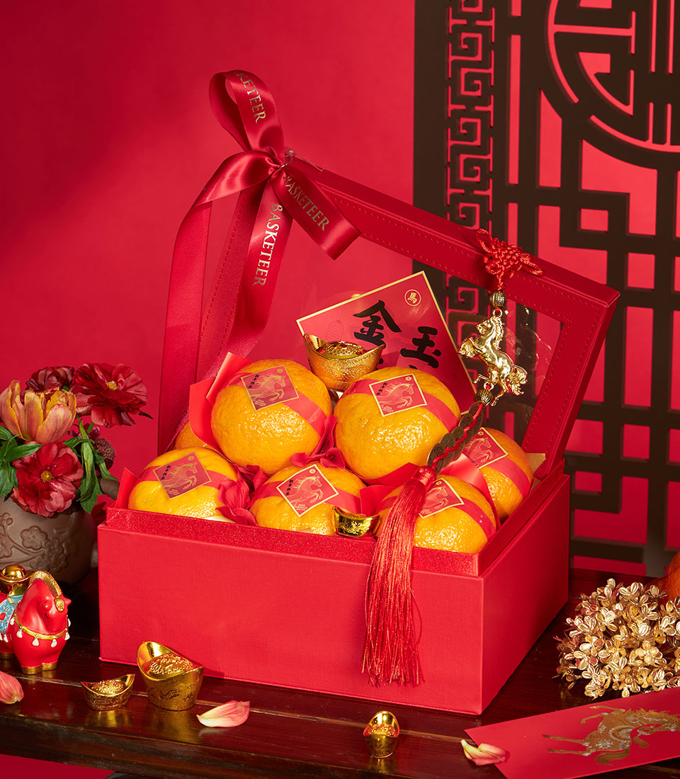 Premium mandarin oranges in red silk gift box with gold accents, festive Chinese New Year hamper
