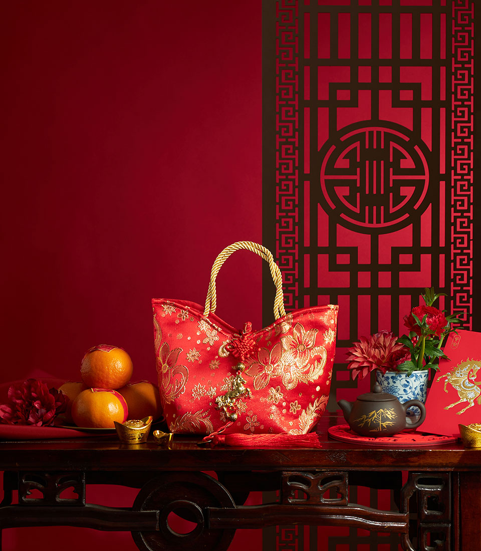 Red satin gift tote with gold embroidery, mandarin oranges, and traditional Chinese New Year symbols