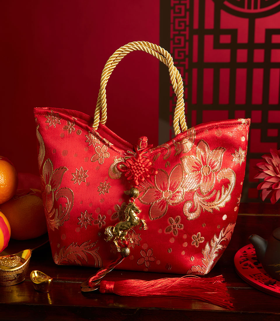 Red embroidered silk gift bag with mandarin oranges, gold accents, and Chinese New Year celebration styling