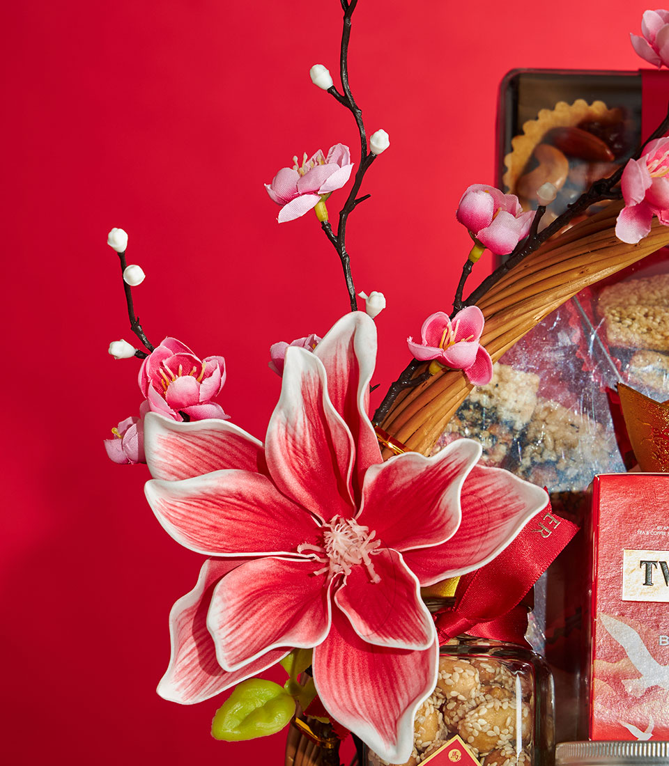 Luxury red gift basket with festive flowers, gourmet treats, and sesame nuts for Chinese New Year celebrations