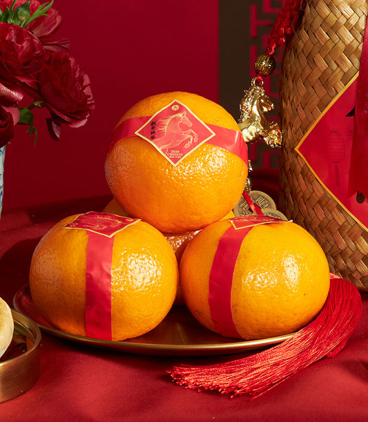 Premium Chinese New Year mandarin orange gift set with red ribbons, gold-rimmed tray, peonies, and festive woven basket