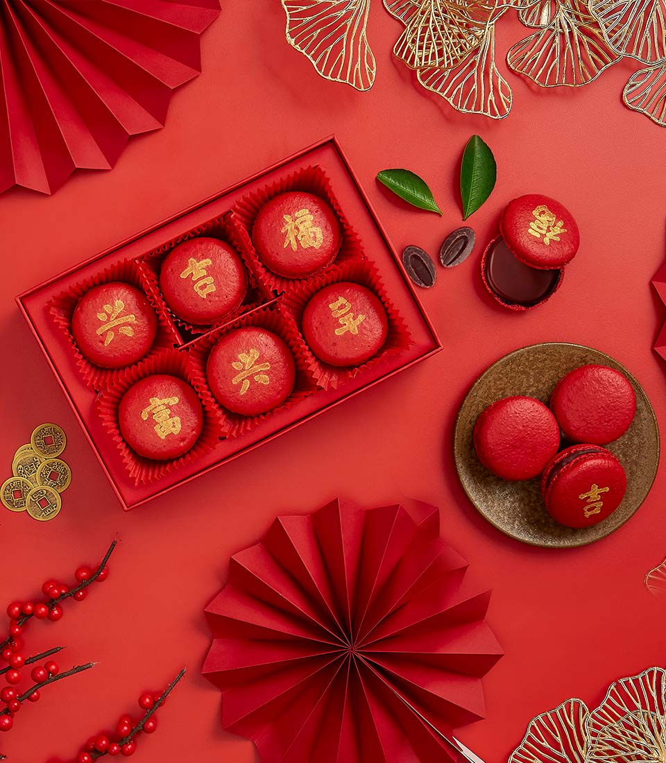 Red macarons embossed with gold Chinese characters for fortune and prosperity, dark chocolate filling, Chinese New Year gift