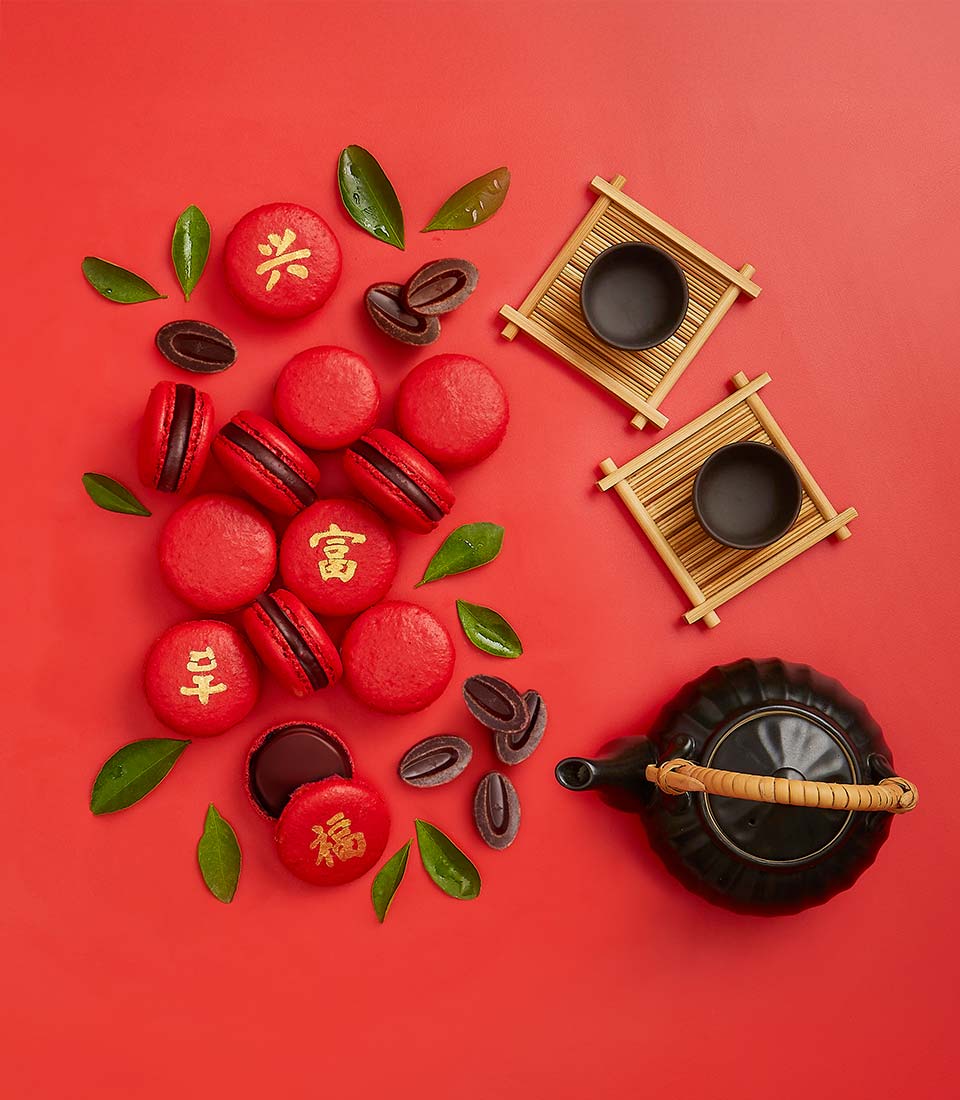 Red chocolate macarons with Chinese characters, dark ganache filling, festive gift set with black ceramic teapot for Chinese