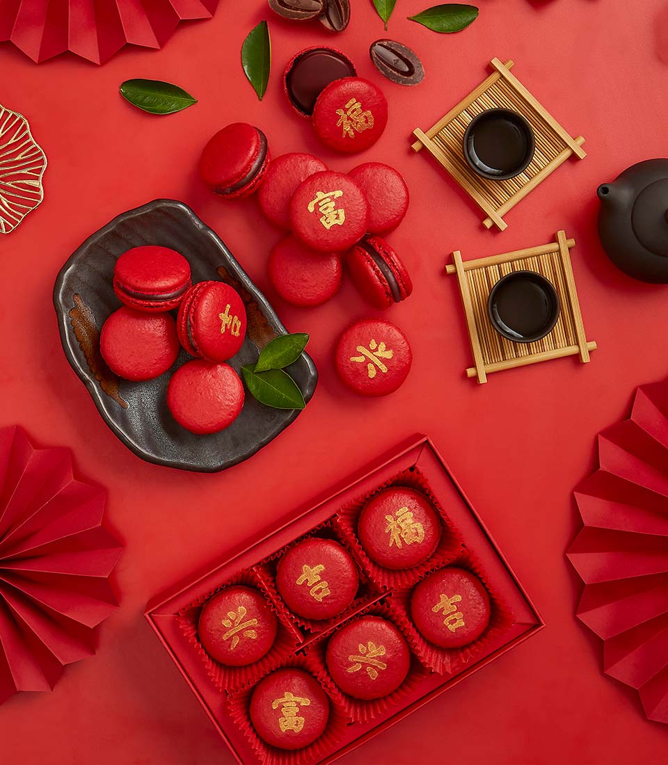 Red macarons with gold Chinese characters in gift box, Lunar New Year fortune chocolate treats