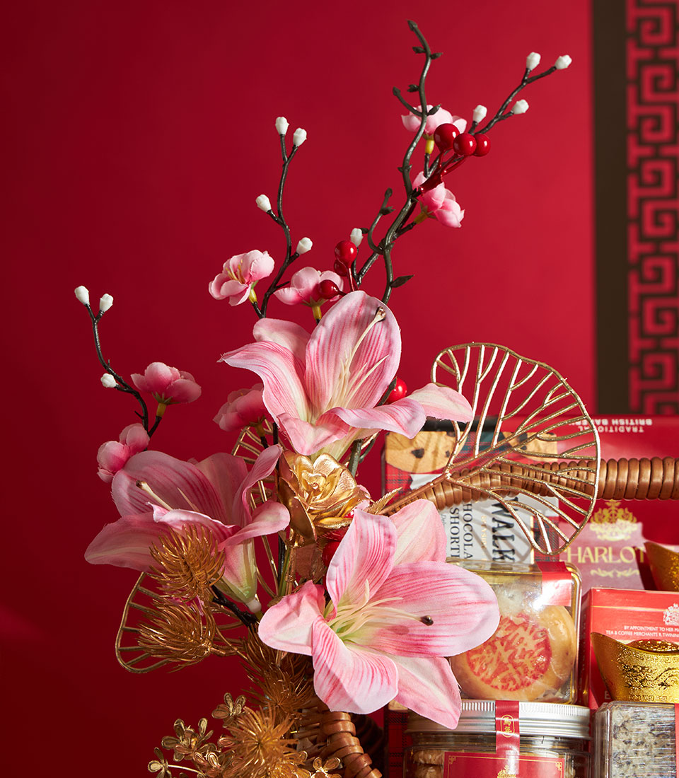Premium Chinese New Year gift basket with gourmet treats, artisan flowers, and gold accents on festive red