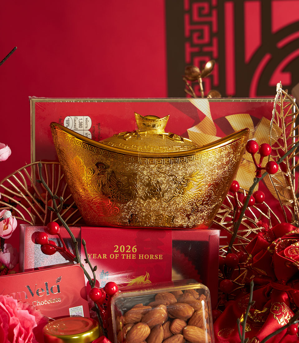 Ultra-luxury Chinese New Year gourmet gift set with golden sycee ingot, red silk box, and artisan chocolates in festive gold