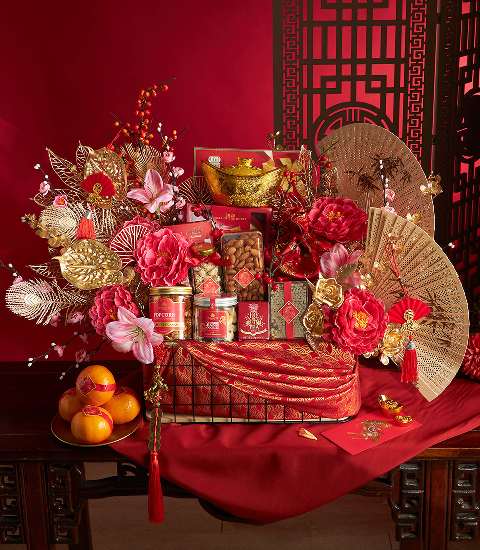 Luxury Chinese New Year gift hamper with red and gold décor, gourmet treats, fresh oranges, and traditional lucky charms