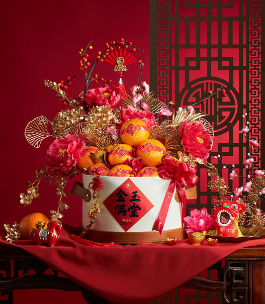 Festive Chinese New Year mandarin orange gift basket with red peonies, gold ornaments, and traditional decorations