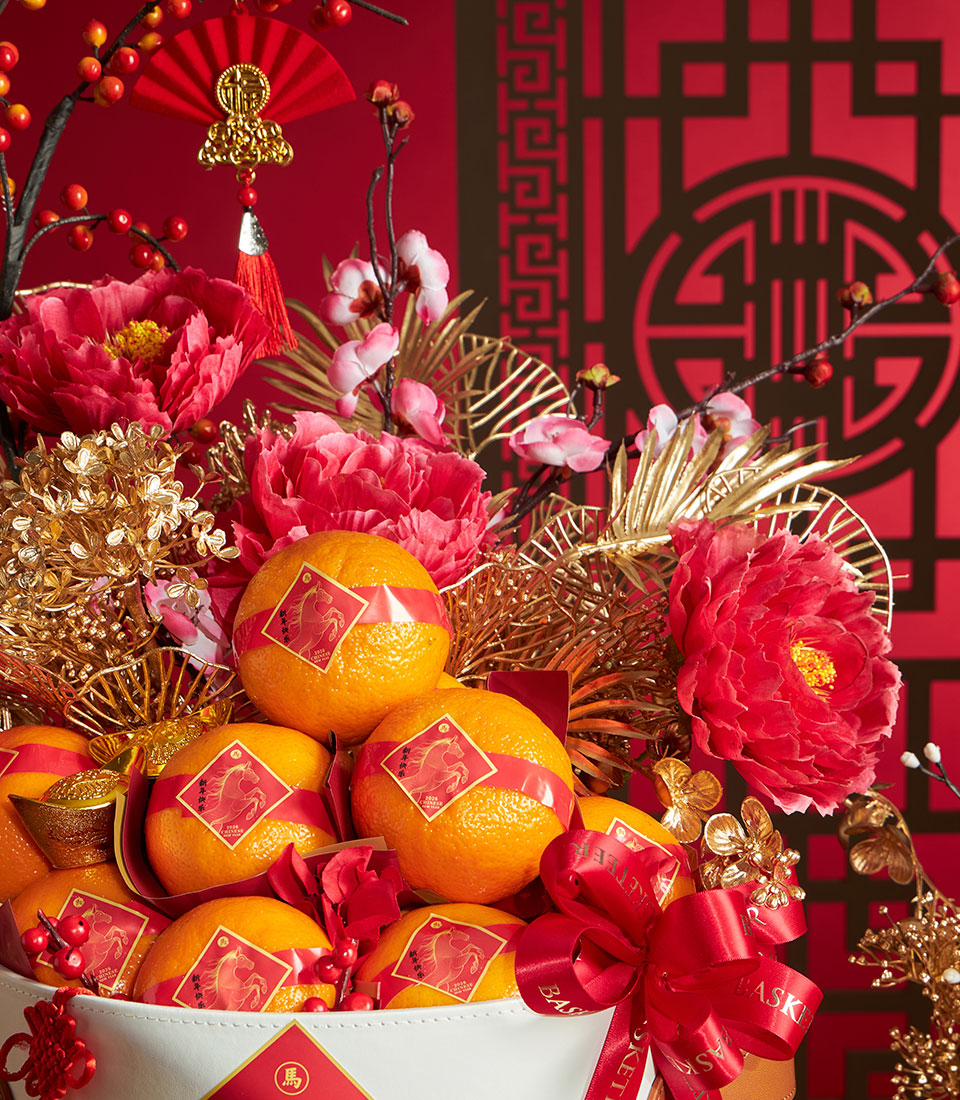 Chinese New Year mandarin orange gift basket with red peonies, cherry blossoms, and gold accents