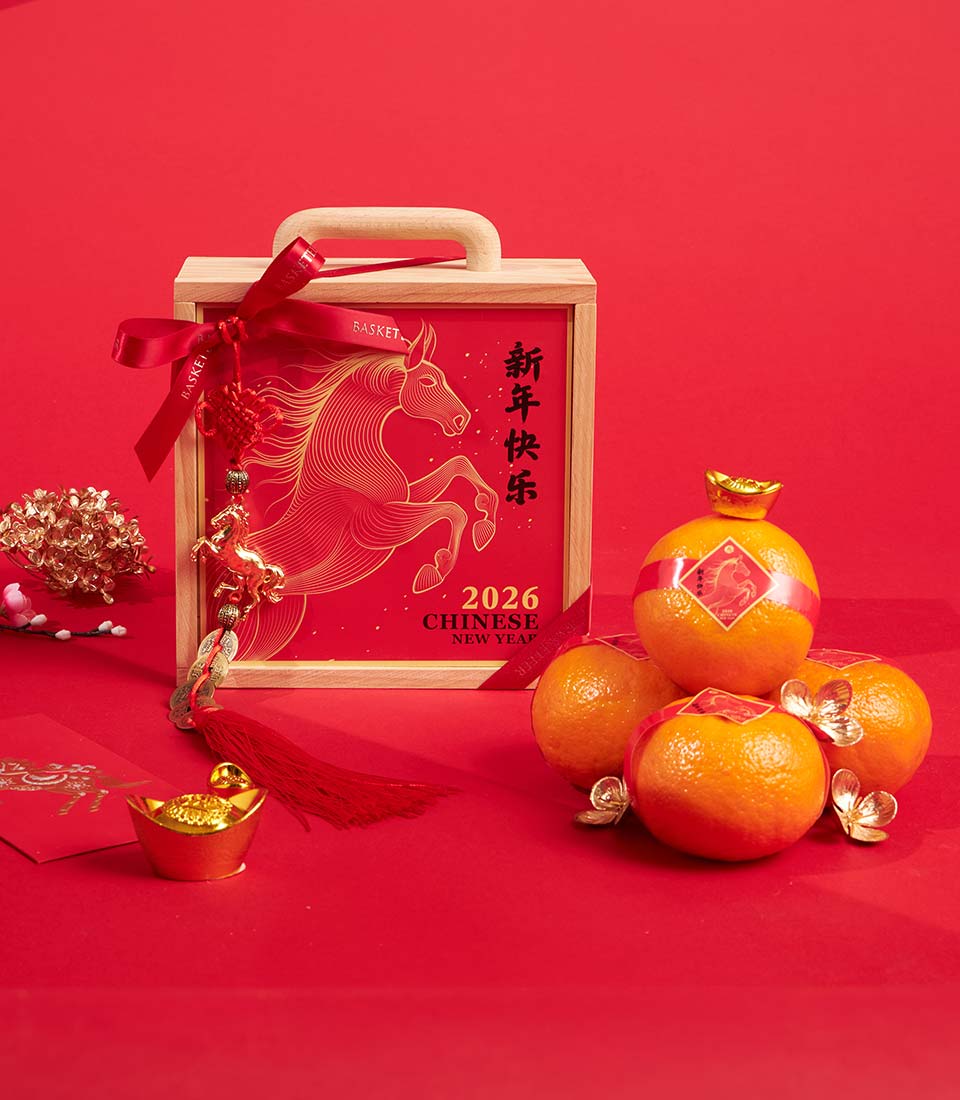 Luxury mandarin orange gift box with red ribbon, golden horse charm, and red envelopes for Chinese New Year celebration