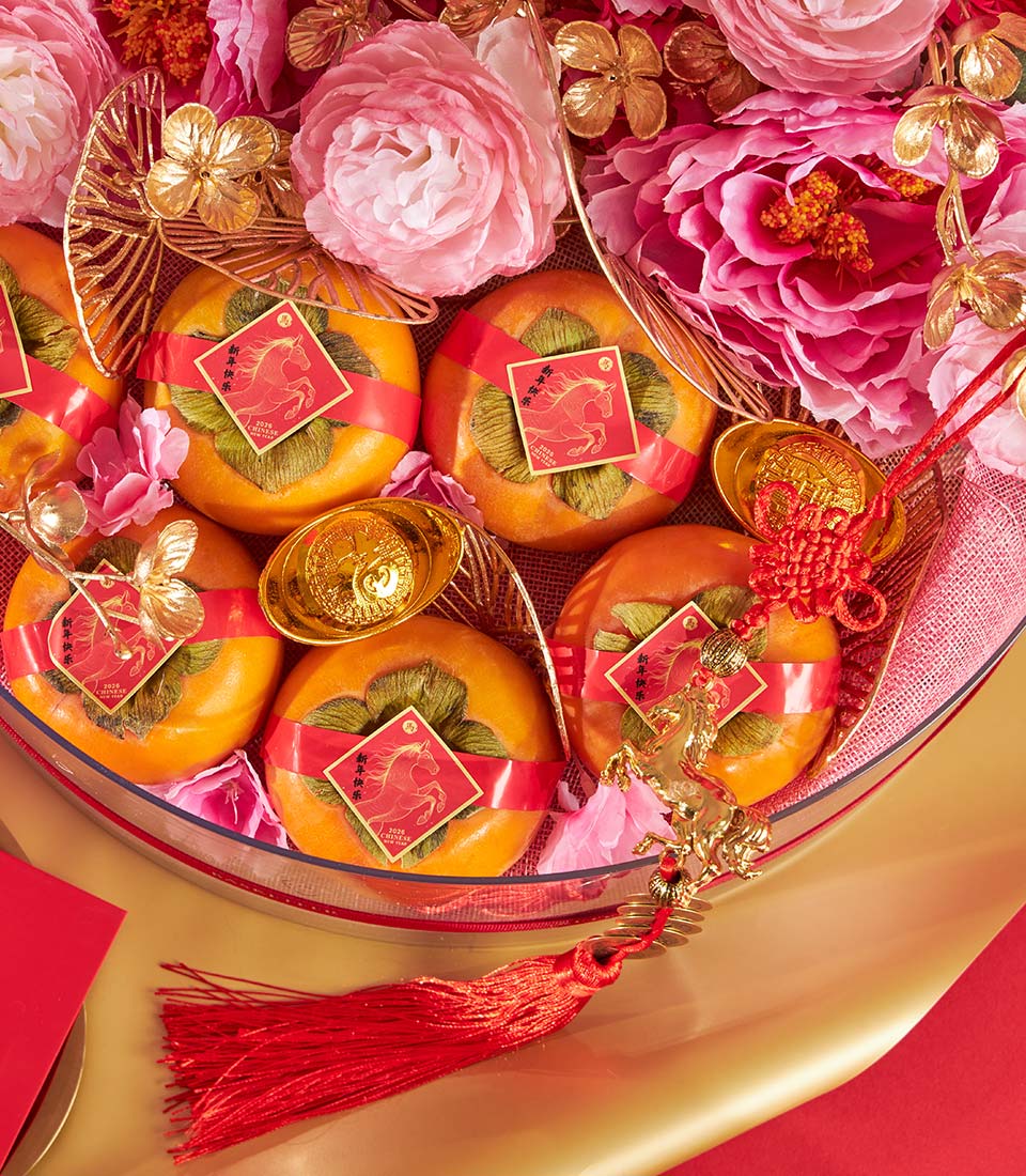 Festive Chinese New Year persimmon gift tray with red ribbons, gold horse charm, and lucky gold accents