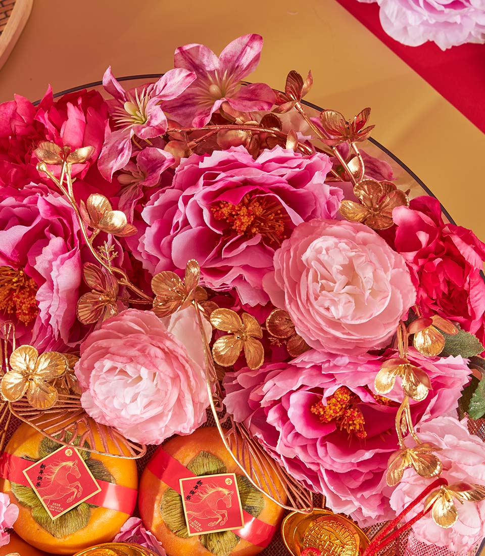 Premium persimmon and mandarin gift tray with pink peonies, golden accents, and Chinese New Year ribbons