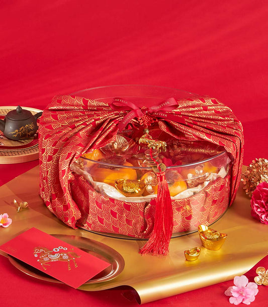 Mandarin orange and persimmon gift tray with gold ingots in red silk wrap, Chinese New Year hamper