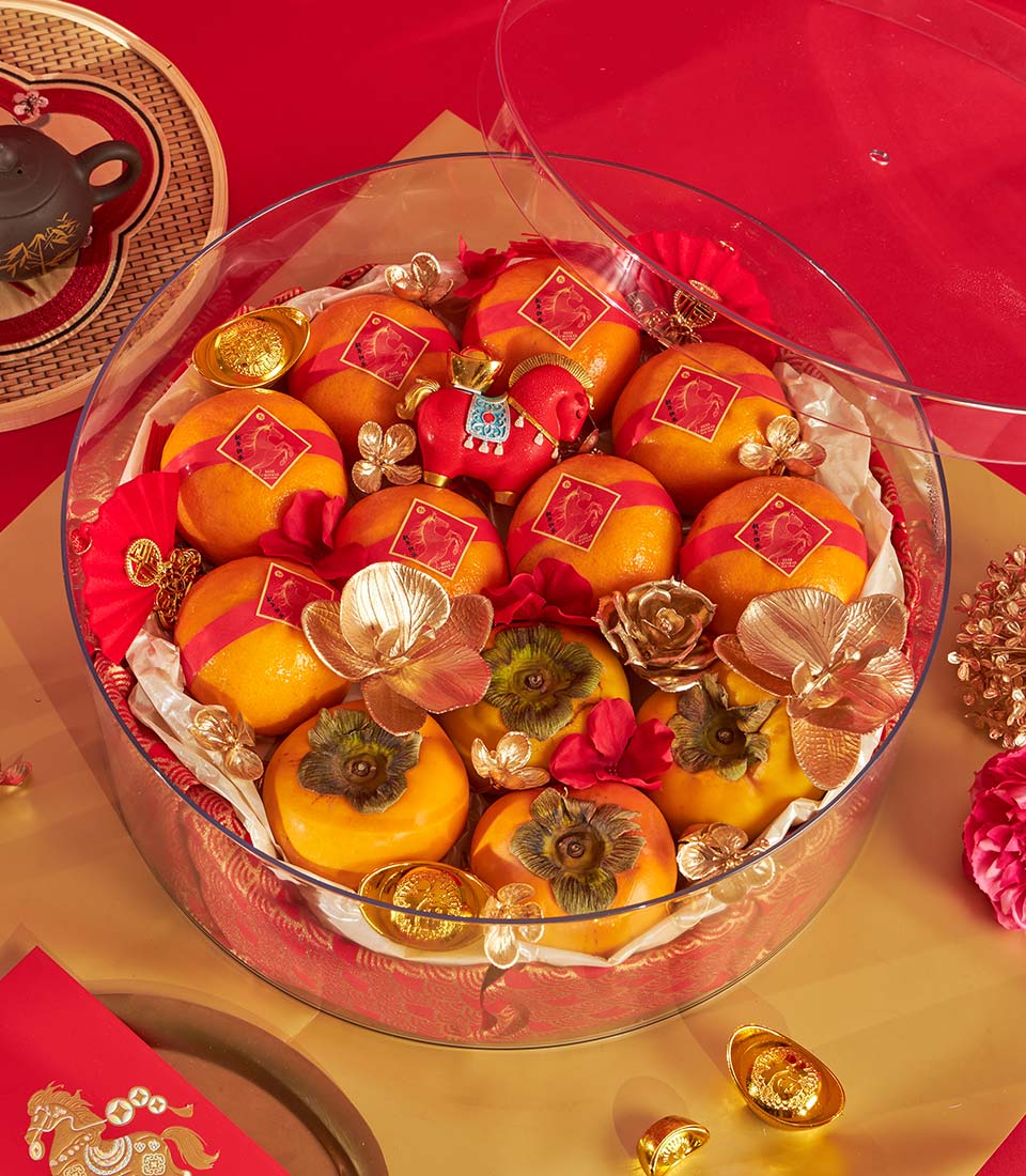 Festive Chinese New Year mandarin orange and persimmon gift tray with red ribbons, gold horse details, and traditional