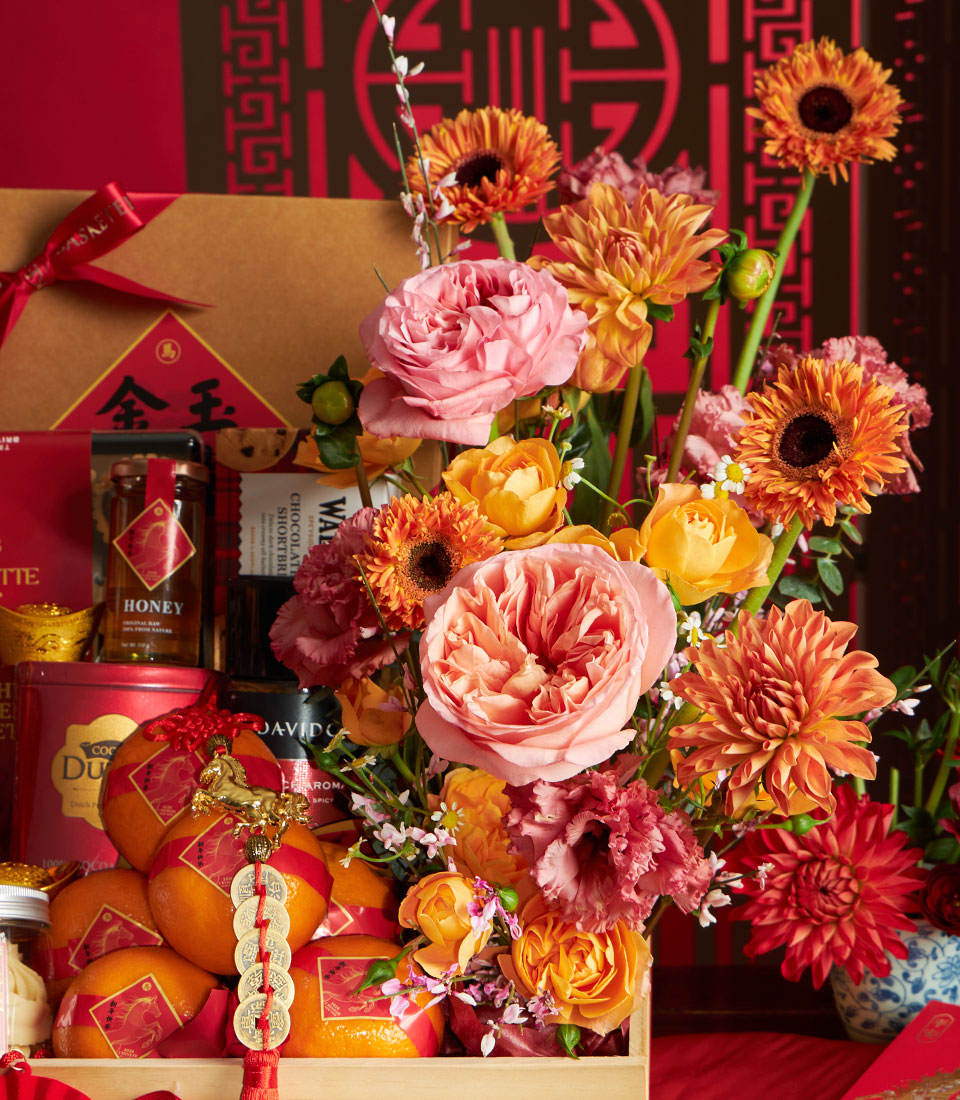 Luxury Chinese New Year gift basket with gourmet honey, chocolates, lucky oranges, and vibrant pink-orange roses with