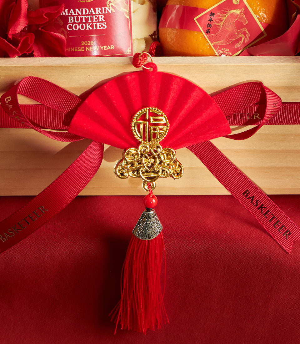Luxury Chinese New Year gift basket with red and gold fu ornament, mandarin butter cookies, and festive oranges in wooden box