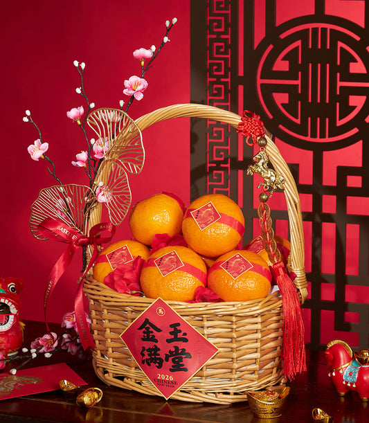 Woven wicker basket with bright mandarin oranges, red ribbons, and gold horse charms for Chinese New Year prosperity gifting