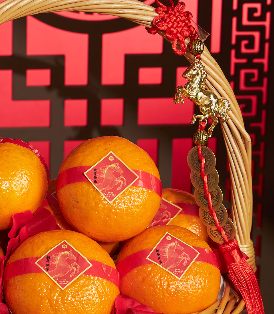 Basketeer's premium Chinese New Year gift: Mandarin oranges in a wicker basket with red ribbon and festive horse charm. Perfect Bangkok hamper delivery.