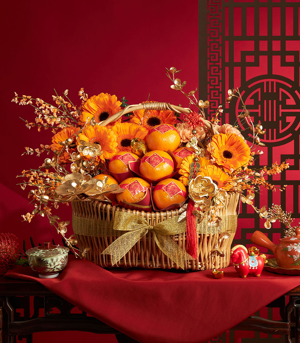 Festive wicker basket filled with mandarin oranges and golden flowers for Chinese New Year celebrations