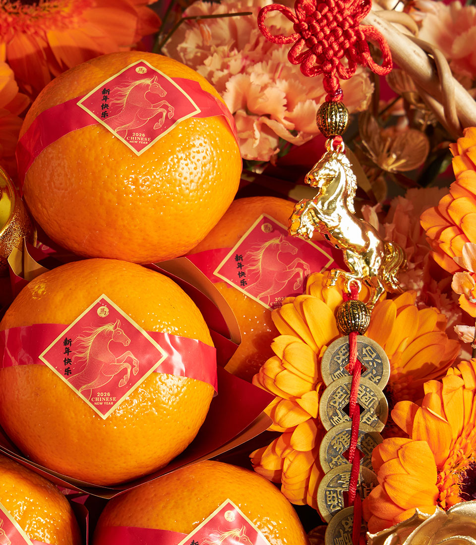 Festive Chinese New Year mandarin orange basket with red and orange flowers, golden horse charm, and lucky coin tassel