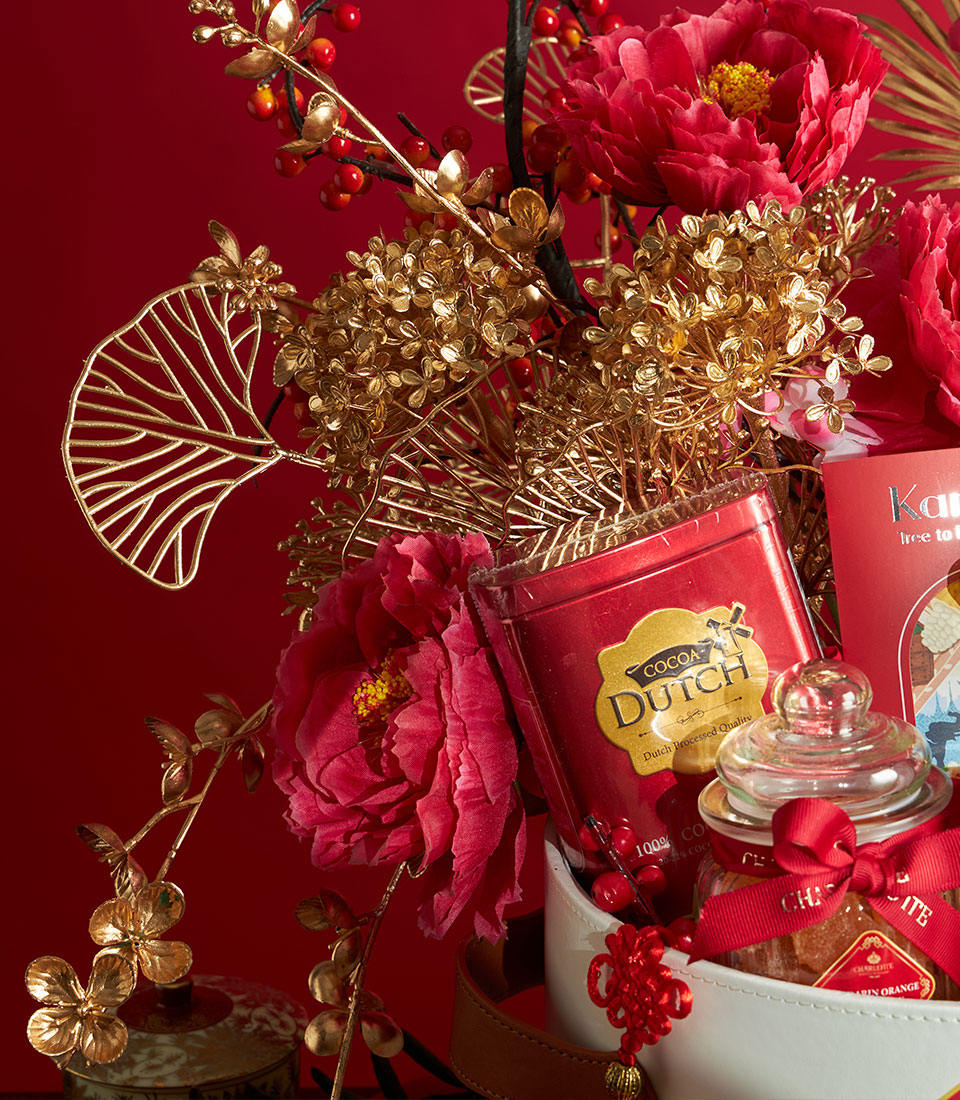 Luxe Chinese New Year gift basket with red cocoa tin, candied mandarin oranges, gold peonies, and festive red accents in