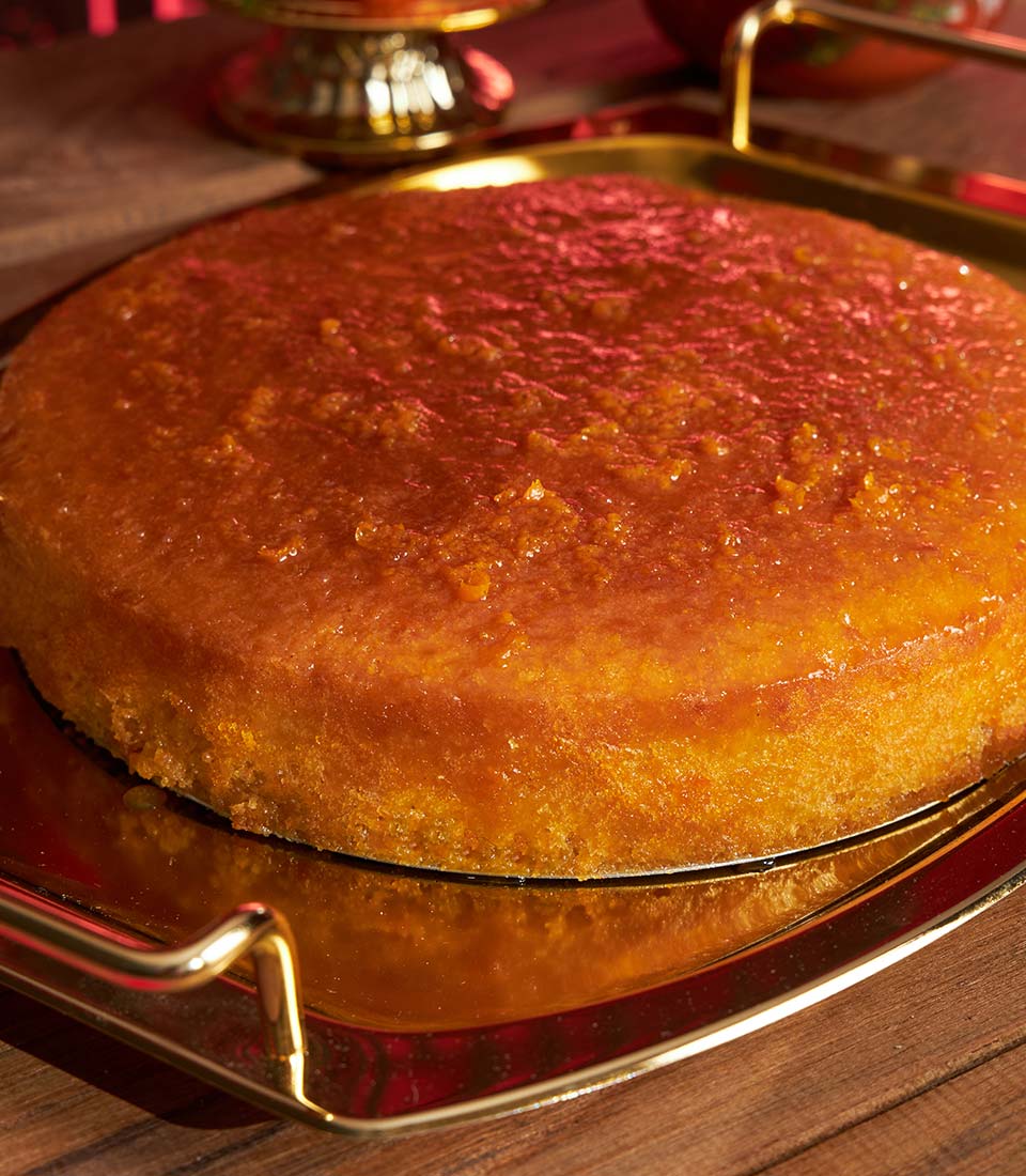 Golden mandarin orange sponge cake with glossy citrus glaze on gold serving tray, Chinese New Year gift