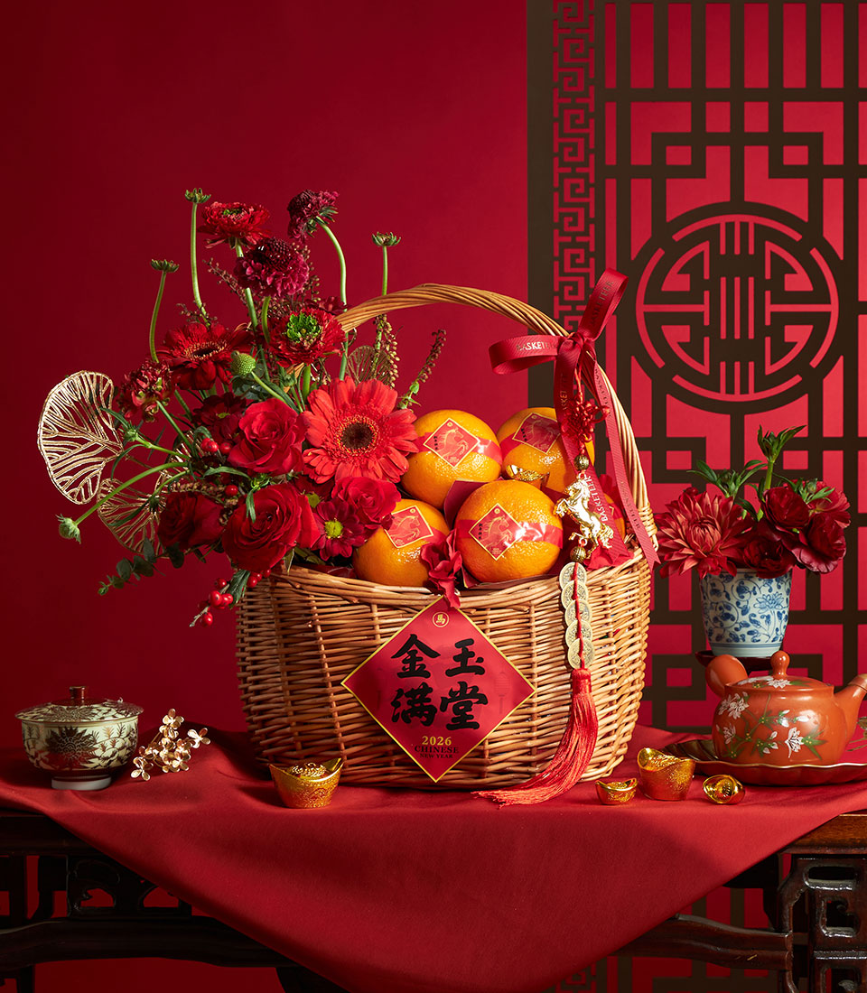 Festive Chinese New Year mandarin orange basket with red roses, gerbera daisies, and lucky gold accents