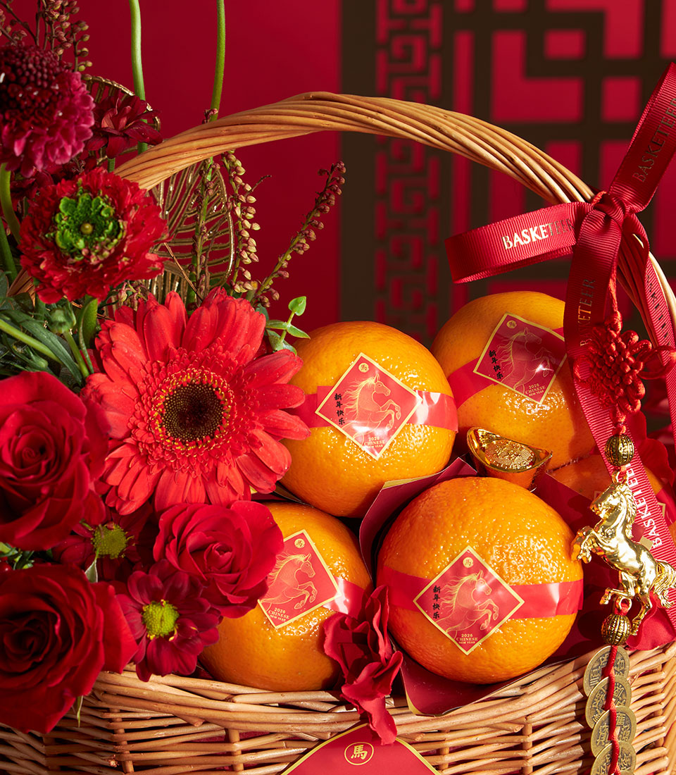 Festive Chinese New Year mandarin orange basket with red roses and gerbera daisies, woven wicker with gold horse charm and