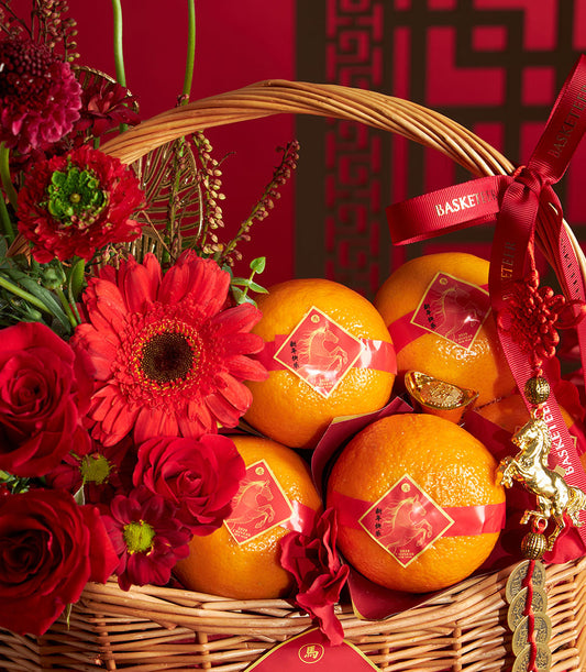 Festive Chinese New Year mandarin orange basket with red roses and gerbera daisies, woven wicker with gold horse charm and