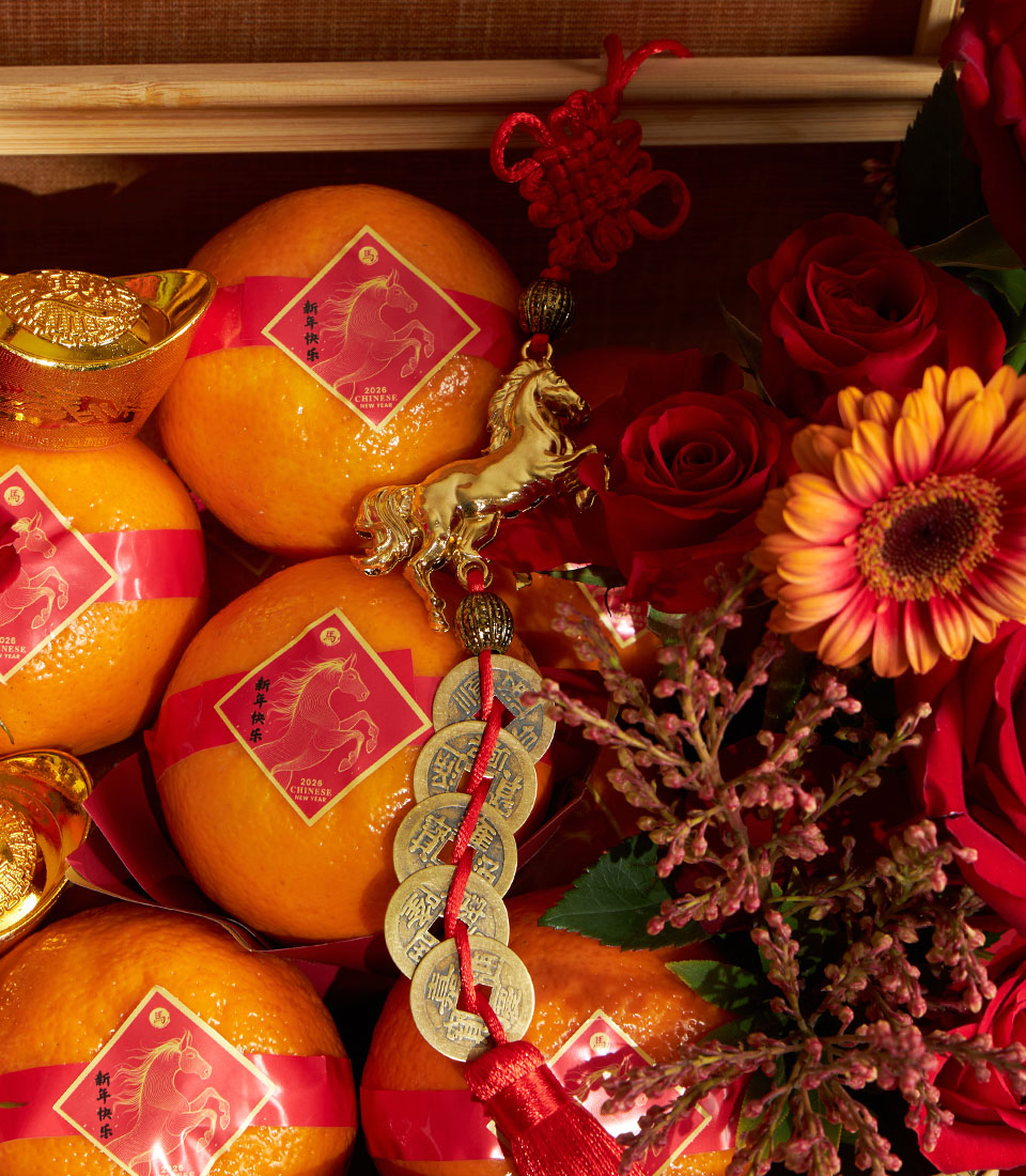 Festive Chinese New Year mandarin orange basket with red roses, gerbera daisy, and golden horse charm