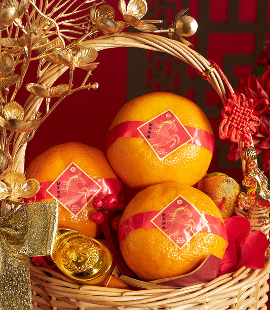 Festive Chinese New Year mandarin orange gift basket with red ribbon, golden horse charms, and woven wicker base