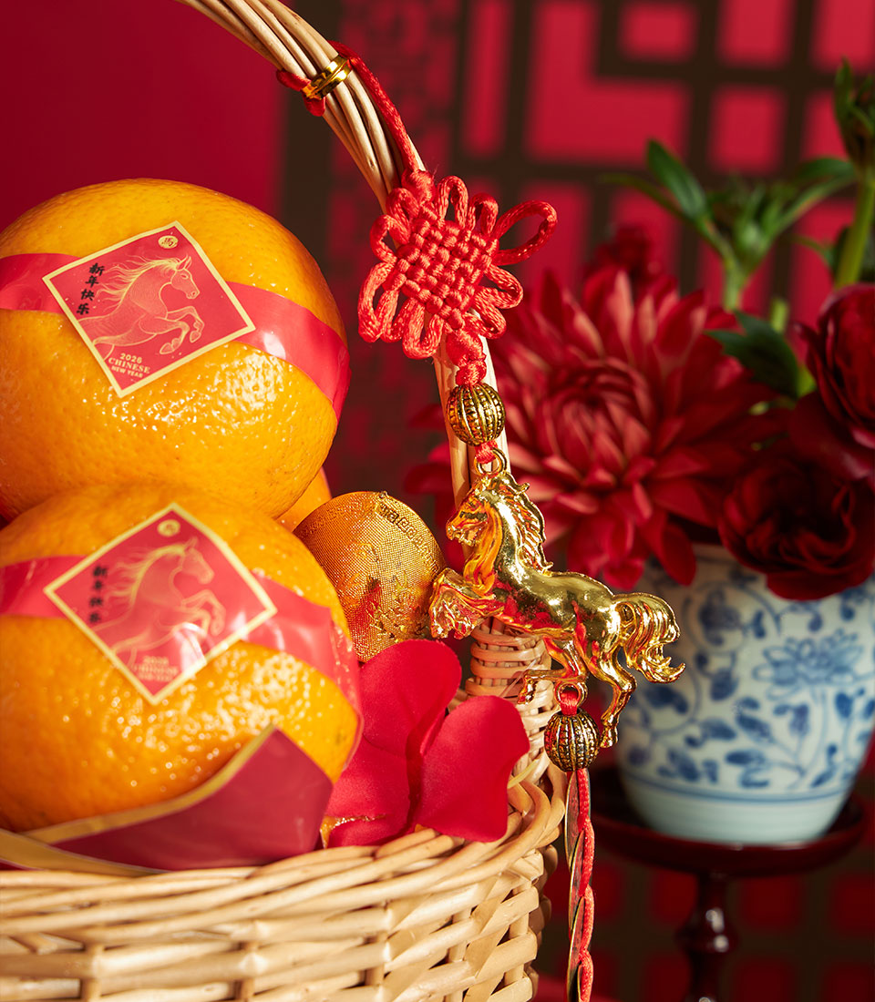 Luxury Chinese New Year mandarin orange gift basket with red floral accents and gold horse charm