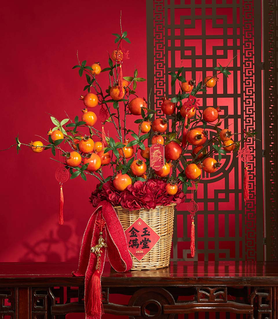 Basketeer premium hamper for Chinese New Year. Pomegranate branch arrangement with red hydrangeas in a wicker basket with decorative tassels. A luxurious gift.