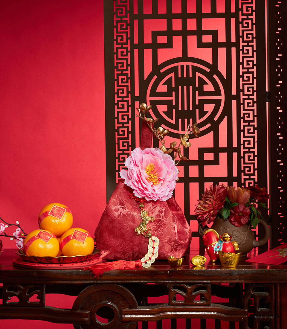 Premium mandarin oranges, red silk pouch, and red flowers with gold accents in Chinese New Year prosperity gift set