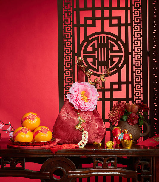 Premium mandarin oranges, red silk pouch, and red flowers with gold accents in Chinese New Year prosperity gift set