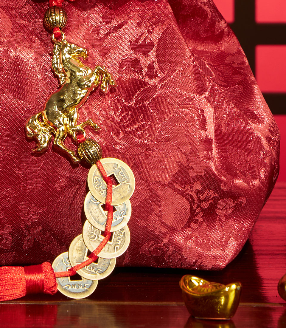 Red silk pouch with golden horse charm and antique Chinese coins for Lunar New Year prosperity