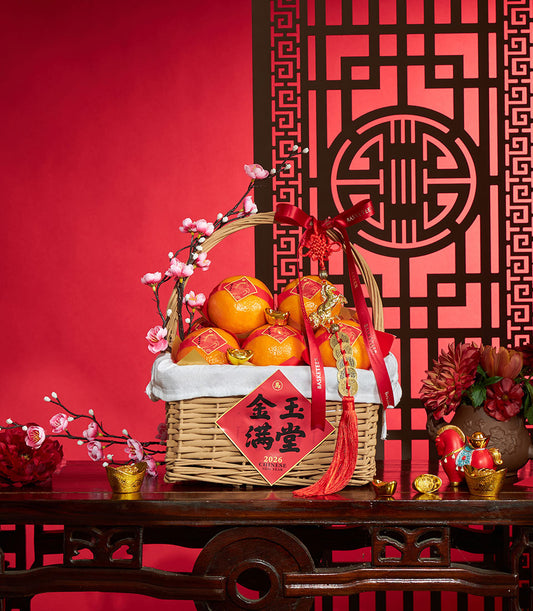 Premium mandarin prosperity basket with red ribbons, gold charms, and festive Chinese New Year decorations on woven wicker