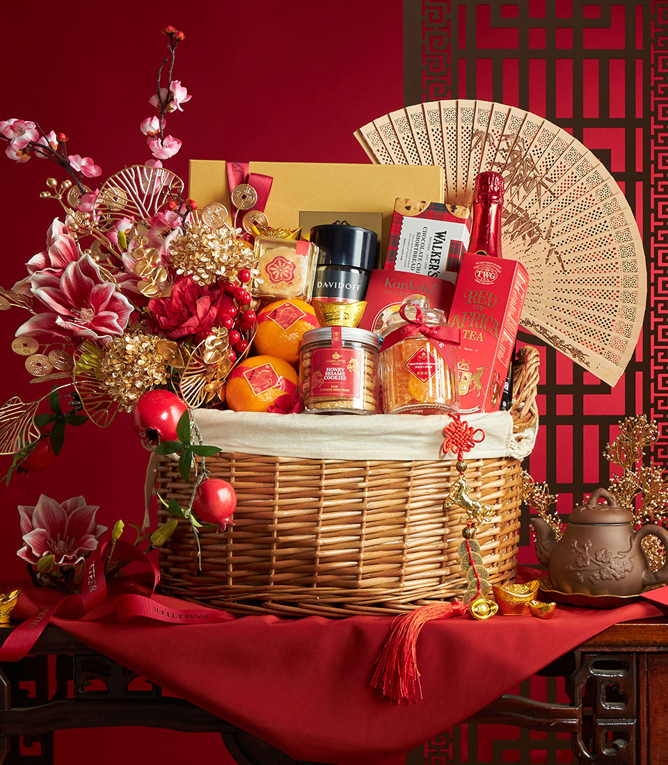 Luxury Chinese New Year gift basket with mandarin oranges, gourmet treats, red flowers, and gold accents