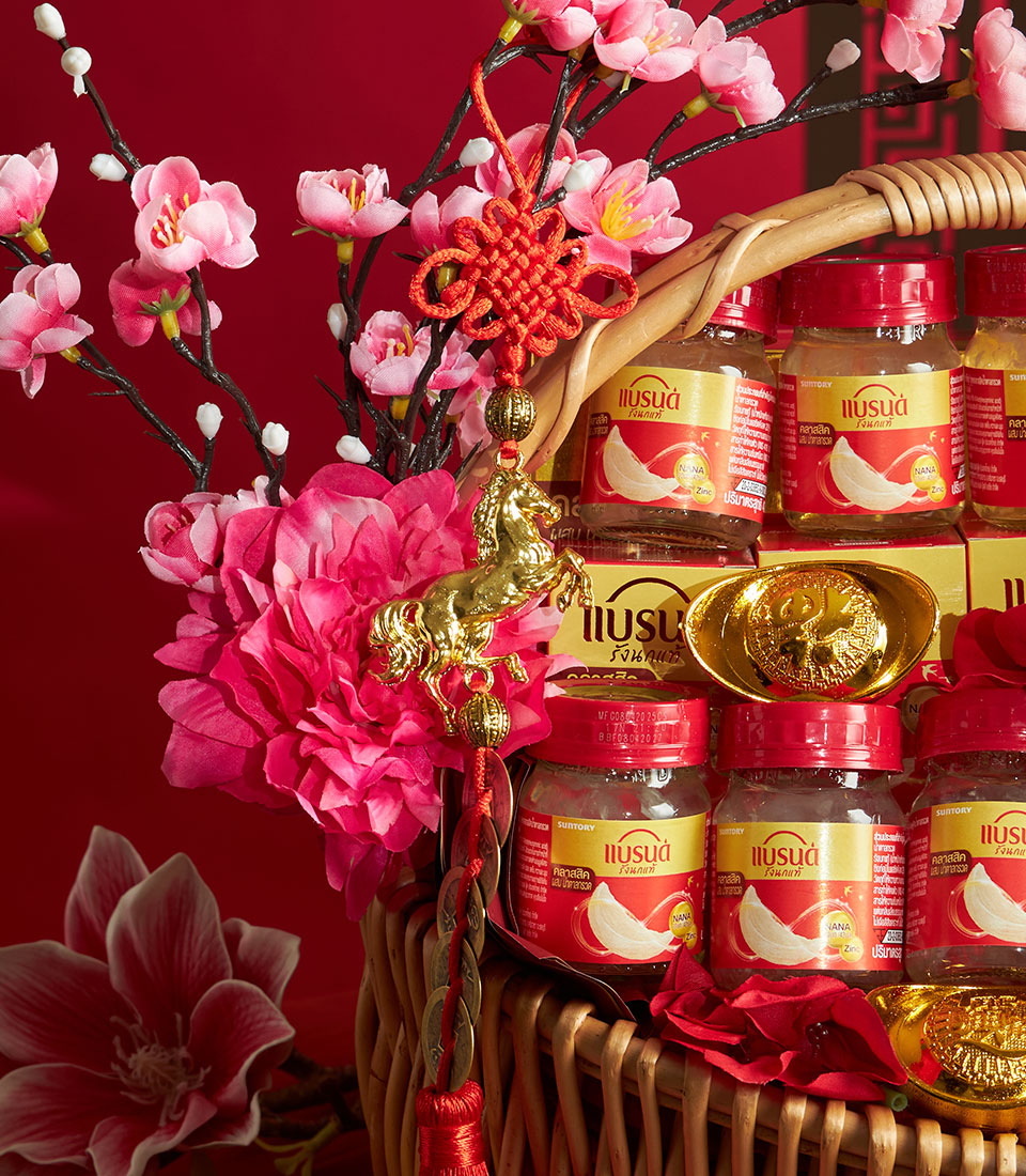 Luxury gift basket with bird's nest jars, golden accents, and cherry blossoms on red background