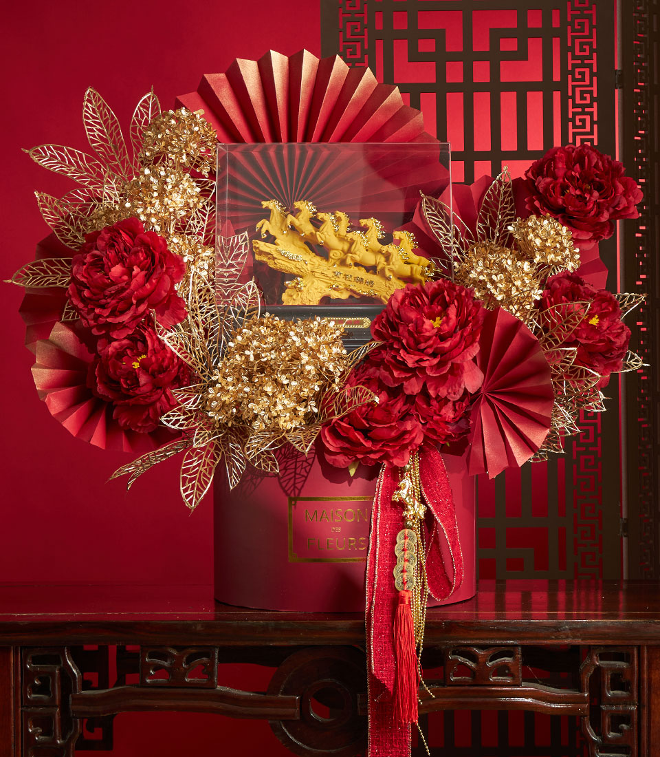 Basketeer premium hamper delivery Thailand: A luxurious floral gift with golden horses sculpture, red peonies and paper fans, tied with a red ribbon. Perfect corporate gift Bangkok.
