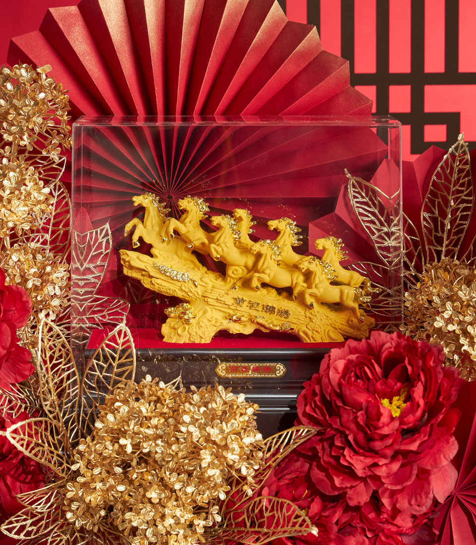 Basketeer luxury gift: Golden horses sculpture, a symbol of success, presented among red paper fans and gold floral accents. Perfect corporate gift Bangkok this CNY.